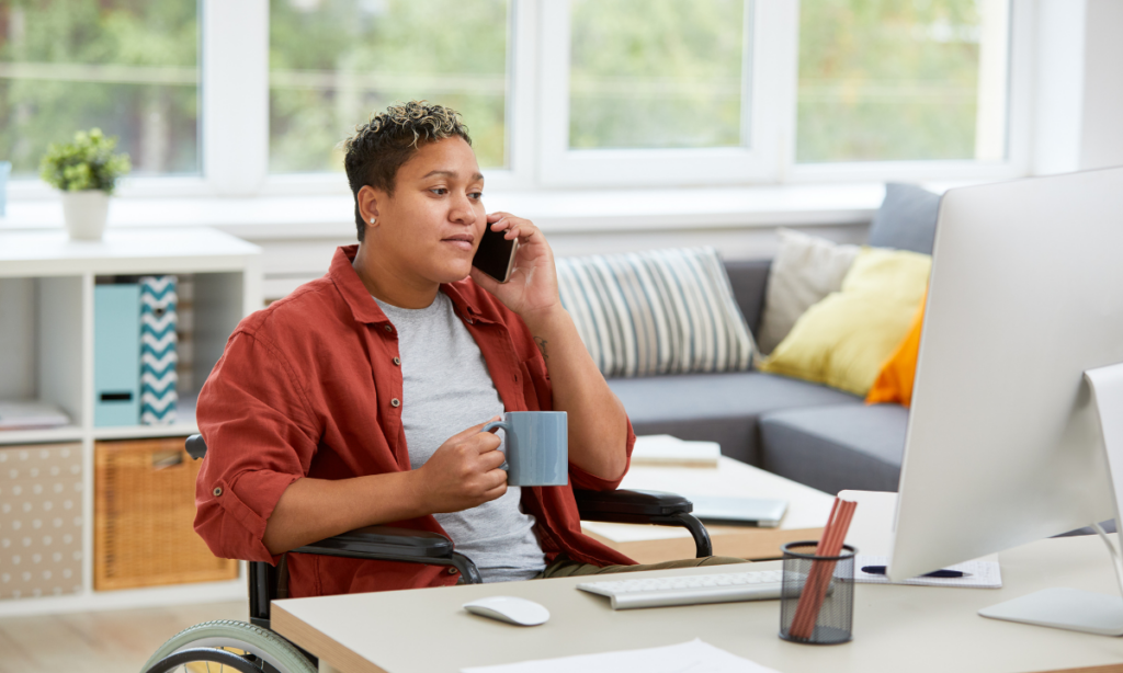 Image of person in wheelchair on the phone at their home desk discussing marketing career options